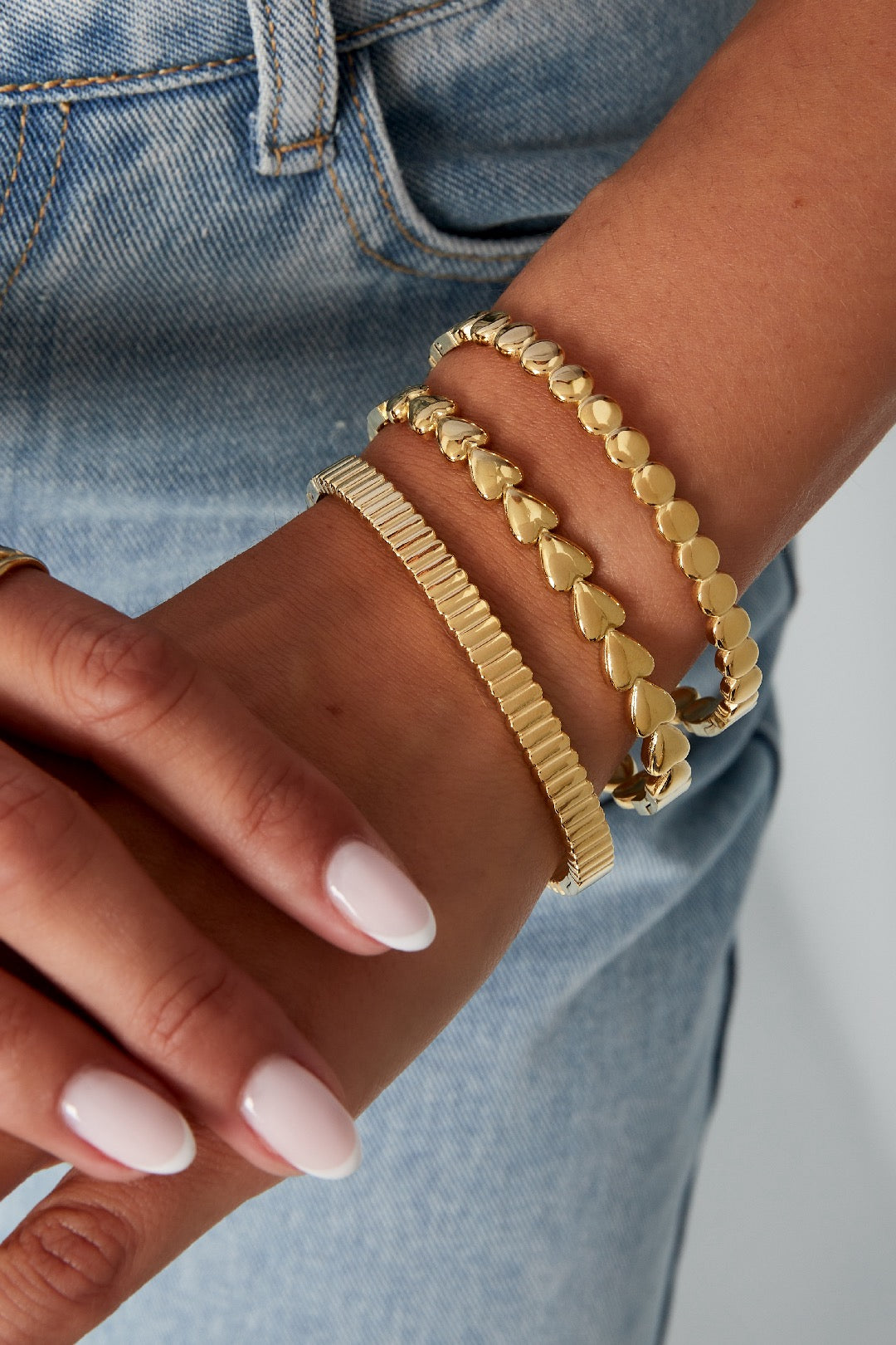 Ständer mit verschiedenen gold und silberfarbenen Edelstahlarmbändern in filigranen Designs.