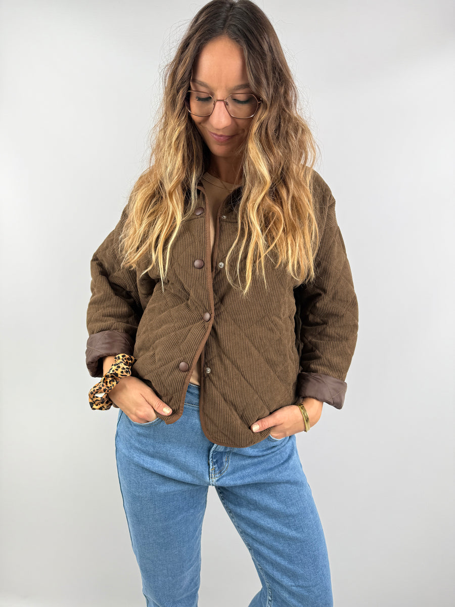 Gesteppte Cordjacke in warmem Braunton, locker kombiniert mit Jeans und Top – stilvoller Übergangslook.
