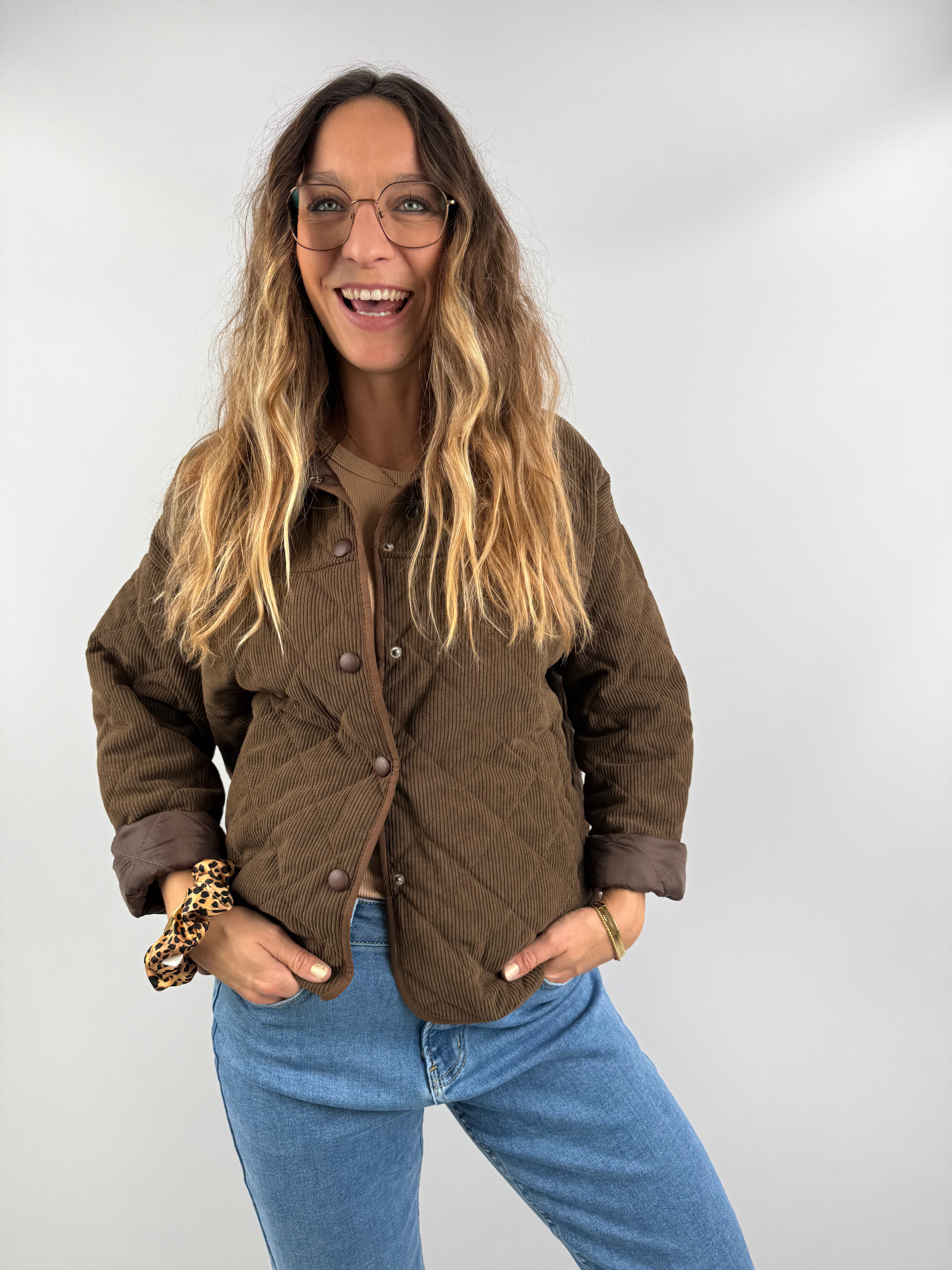 Braune Cordjacke mit Steppmuster und aufgeschlagenen Ärmeln – kombiniert mit Jeans für einen modernen Casual-Look.