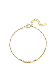 Filigranes vergoldetes Edelstahl-Armband mit Kugeln, am Handgelenk getragen.