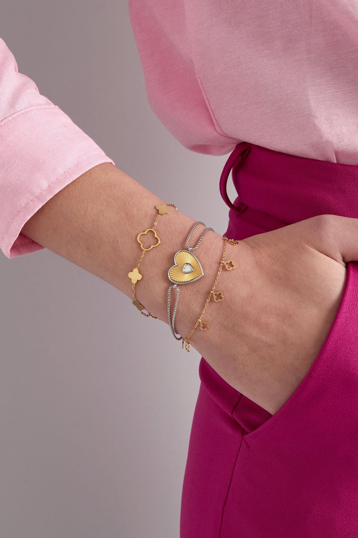 Kleeblatt-Armband in Gold kombiniert mit weiteren Armbändern am Handgelenk