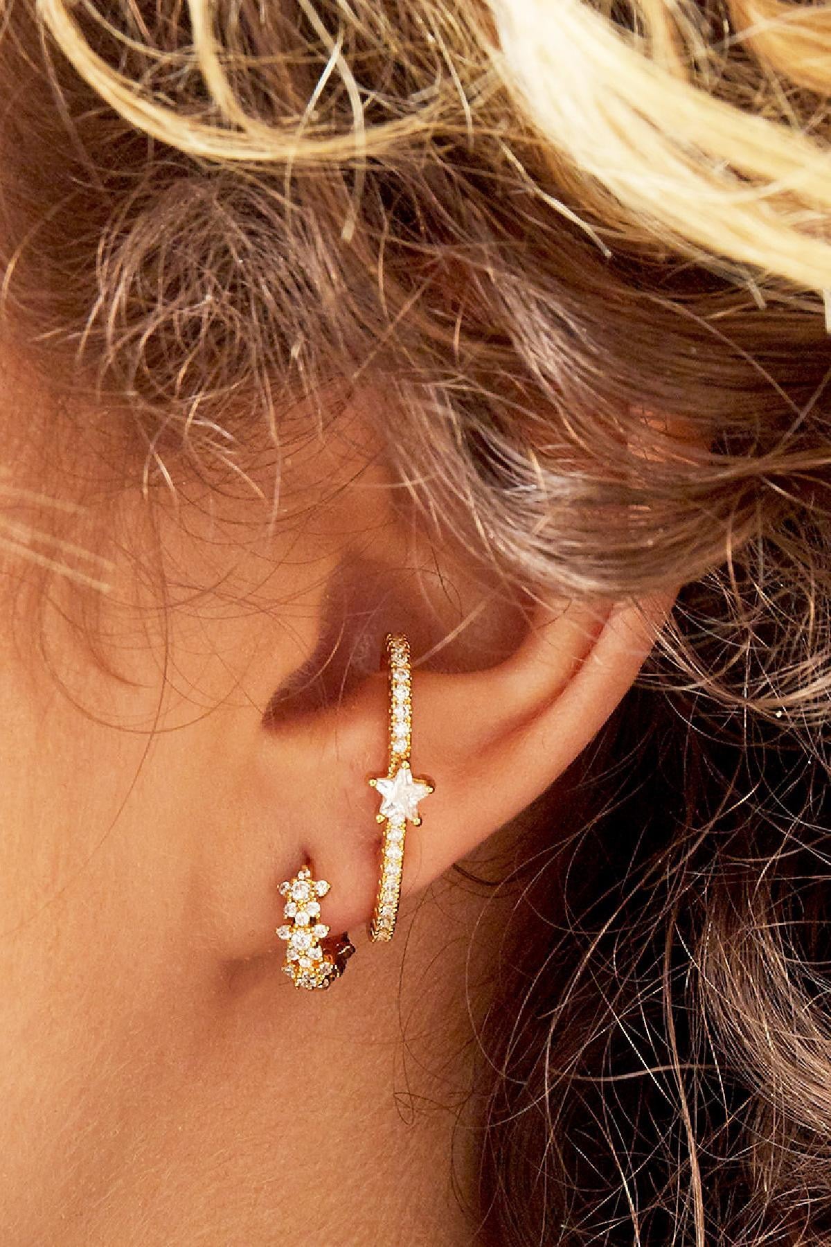 Detailaufnahme goldene Mini-Creolen mit Zirkonia-Steinen im Ohr – eleganter Look.