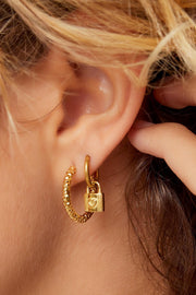 Goldene gehämmerte Creolen aus Edelstahl, getragen im Ohr – eleganter Look.