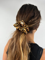 Profilansicht einer Frau mit Leo-Seiden-Scrunchie im Haar – eleganter und pflegender Look für den Alltag.
