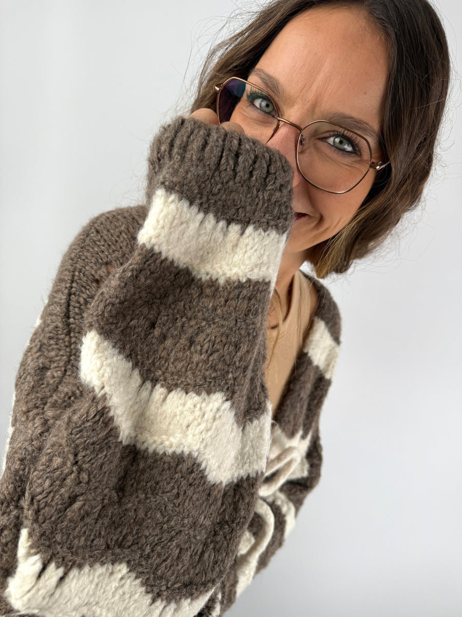 Detailaufnahme der flauschigen Strickjacke in Braun und Creme – weiche Struktur und gemütliche Passform.