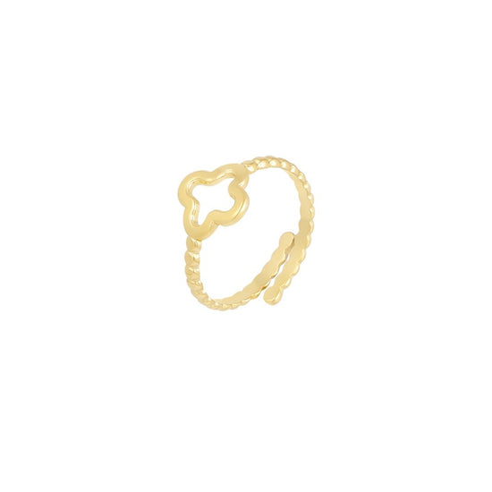 Gedrehter Ring mit Kleeblatt in Gold auf hellem Hintergrund – minimalistischer Schmuck mit feinem Glanz.