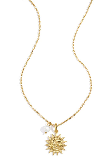 Goldfarbene Halskette mit Sonnenanhänger auf hellem Hintergrund
