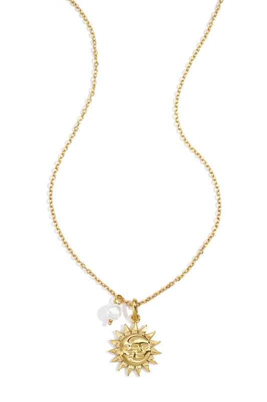 Goldfarbene Halskette mit Sonnenanhänger auf hellem Hintergrund