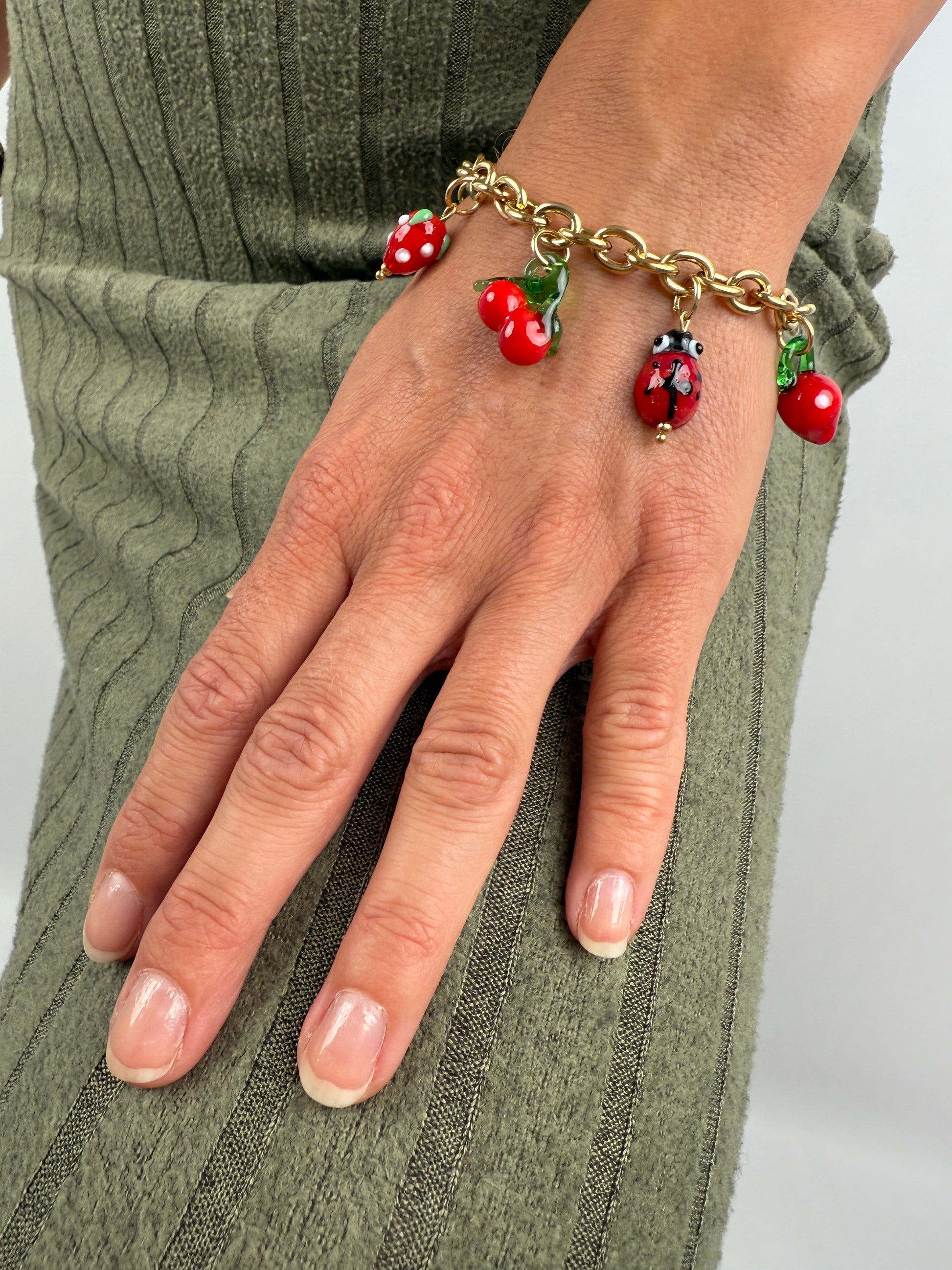 Edelstahl Armband mit bunten Glas Charms in Form von MArienkäffer, Zitrone, Kirsche und Erdbeere.