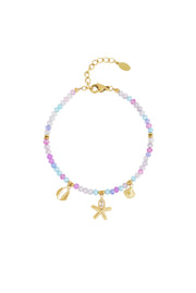 Edelstahl Armband mit Glas und Naturstein Perlen und goldenen Edelstahlanhängern im maritimen Design in pastelligen Lila und Blau Tönen.