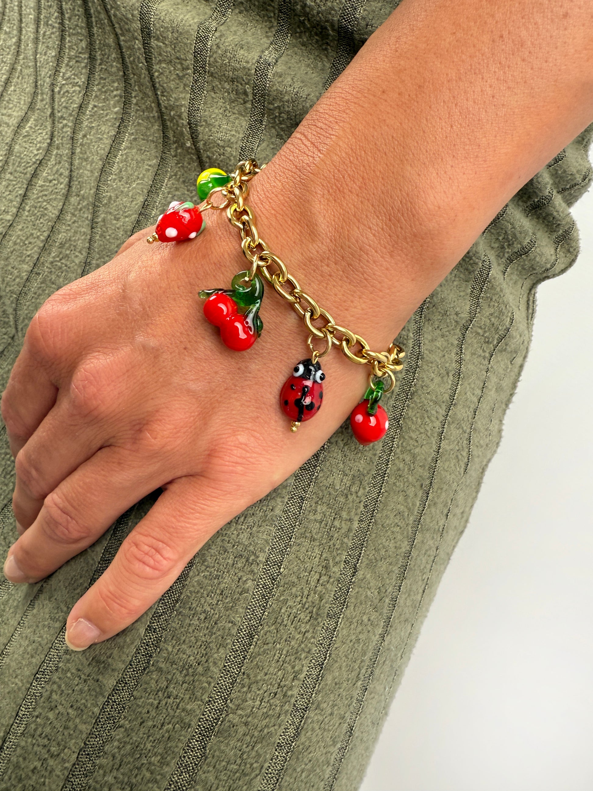 Edelstahl Armband mit bunten Glas Charms in Form von MArienkäffer, Zitrone, Kirsche und Erdbeere.