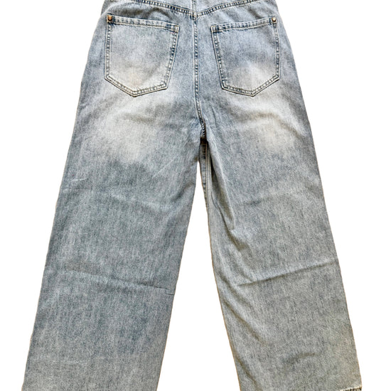 Hellblaue Baggy Jeans mit buntem Anhänger.