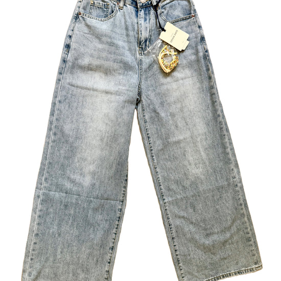 Hellblaue Baggy Jeans mit buntem Anhänger.