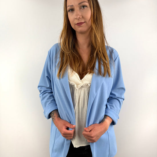 Hellblauer Blazer mit umgeschlagenen Ärmeln und Perlenknopf-Detail.