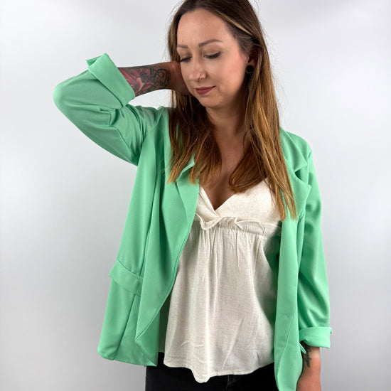 Mintgrüner Blazer kombiniert mit weißem Top.