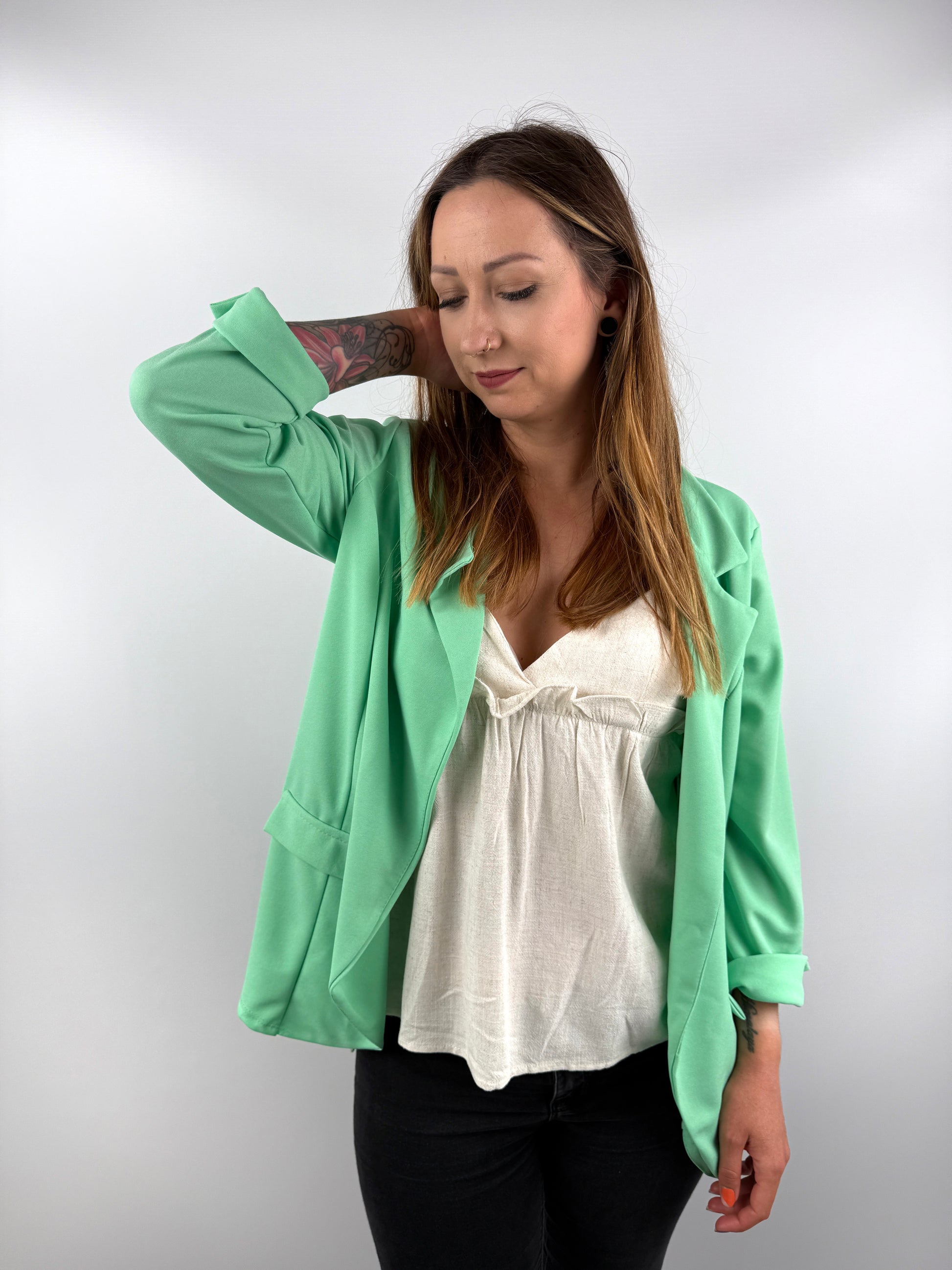 Mintgrüner Blazer kombiniert mit weißem Top.