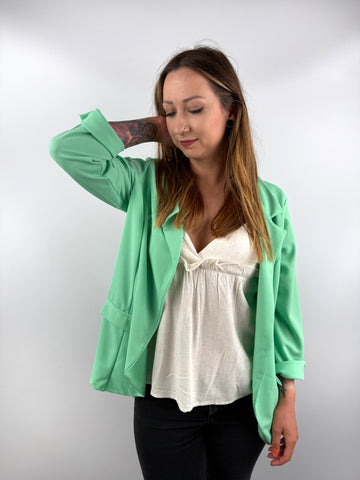 Mintgrüner Blazer kombiniert mit weißem Top.