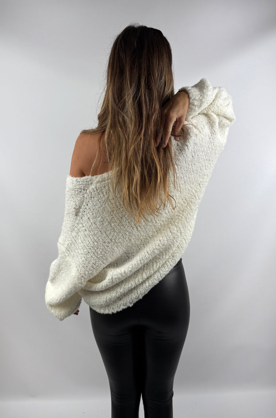 Rückansicht der weißen Strickjacke – lockerer Schnitt und weiches Strickmaterial mit hohem Wollanteil für maximalen Komfort.