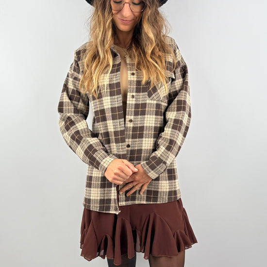 Kariertes Overshirt in warmen Brauntönen, kombiniert mit Rock und beigem Top – lässiger, moderner Herbststil mit rustikalem Touch.