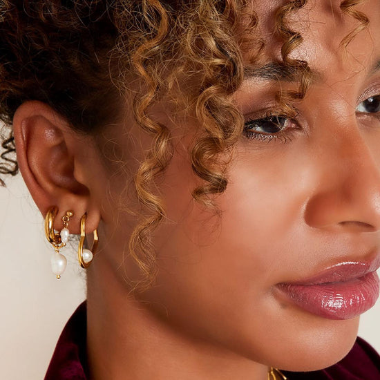 Dickere goldene Creole mit weißer Süßwasserperle als Anhänger.