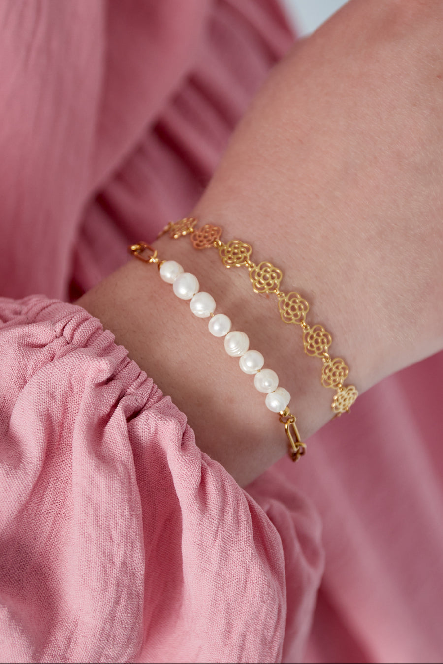 Goldenes Edelstahl Armband mit großen Kettengliedern und aneinander gereihten weißen Süßwasserperlen.