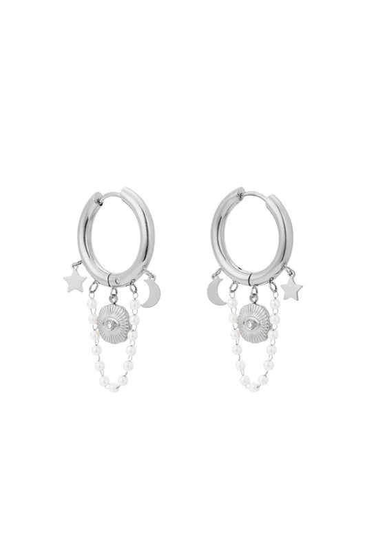 Edelstahl Creolen mit klienen Anhängern in Form von Mond, Stern und einer kleinen Perlenkette mit weißen Perlen und einem Nazar Auge in silberner Farbe.