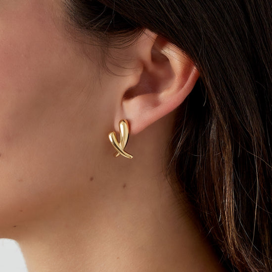 Feine goldene Ohrstecker im gekreuzten Design.