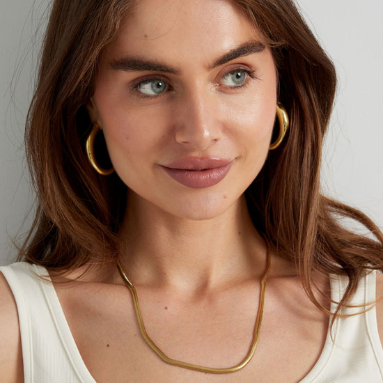 Flache goldene Halskette in Schlangenketten Design. 