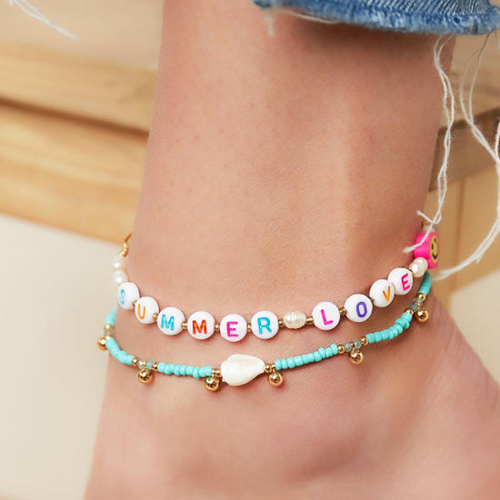 Süßes Fußkettchen bestehend aus Perlen und Muschel und hängenden goldenen Edelstahl Perlen.