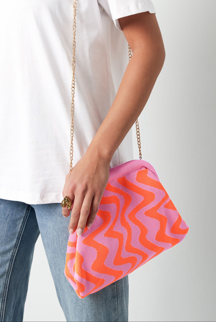 Coole Stoffhandtasche mit Wellenartigem Muster in Pink Orangen Farben und goldener dünner Trage Kette.