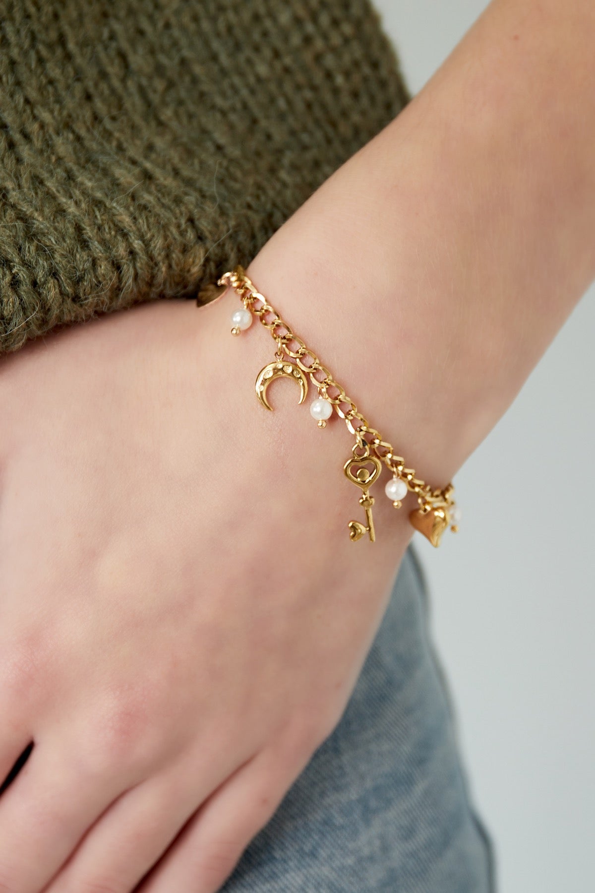 Charm-Armband in Gold am Handgelenk getragen