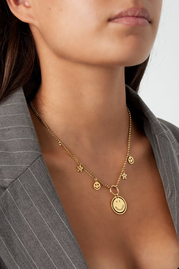 Smiley Charm Halskette in Gold getragen – Detailansicht am Hals