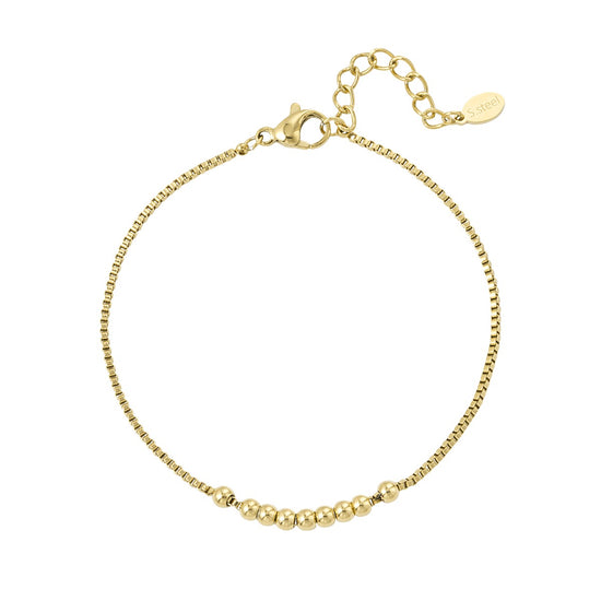 Filigranes vergoldetes Edelstahl-Armband mit Kugeln, am Handgelenk getragen.