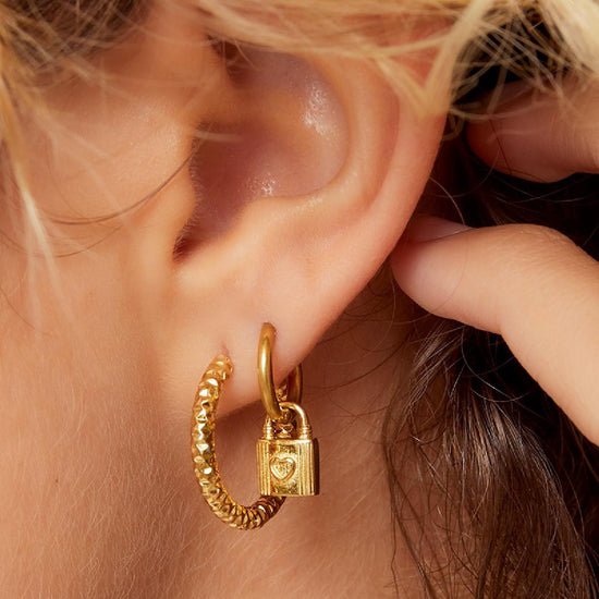 Goldene gehämmerte Creolen aus Edelstahl, getragen im Ohr – eleganter Look.