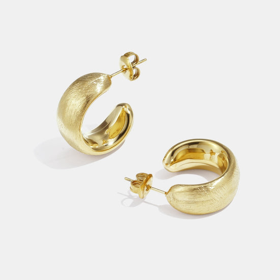 Detailaufnahme von gebürsteten goldenen Chunky-Creolen.