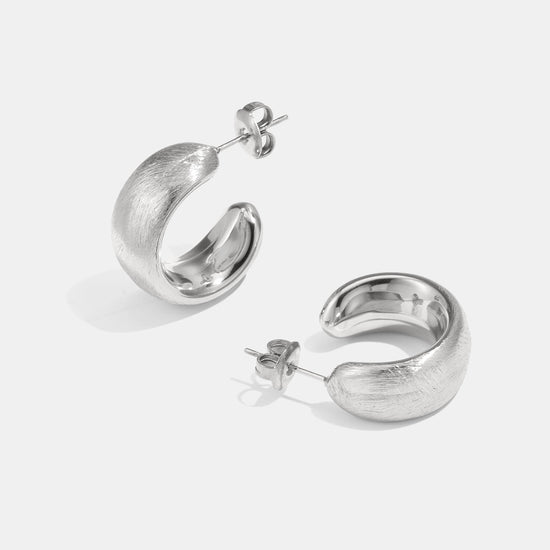 Detailaufnahme von silbernen Chunky-Creolen im modernen Stil.