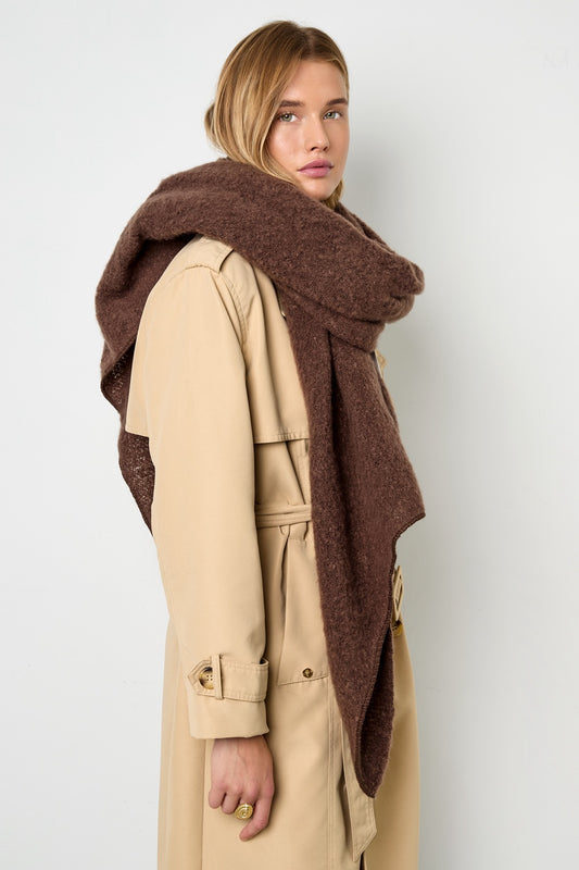 Model trägt braunen, voluminösen Oversized-Schal zu beigem Trenchcoat.