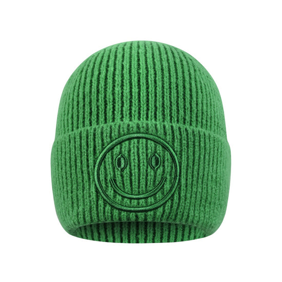 Grüne Smiley-Beanie auf weißem Hintergrund.