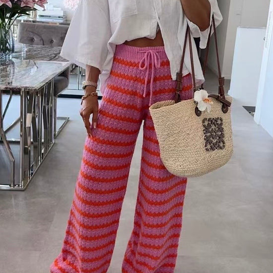 Model trägt gestrickte Streifenhose in Pink und Rot mit weitem Bein