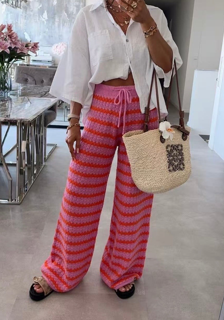 Model trägt gestrickte Streifenhose in Pink und Rot mit weitem Bein