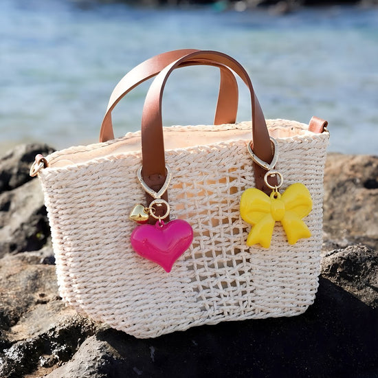 Geflochtene Strandtasche mit pinkem Herzanhänger und gelbem Schleifen Taschenanhänger