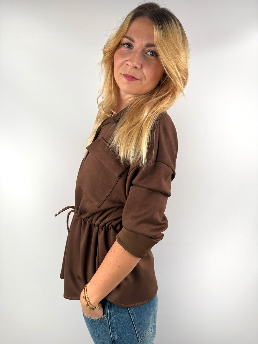 Seitenansicht der braunen Jacke mit Bindung in der Taille.