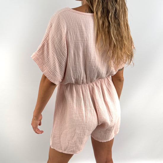 Rosa farbener Musselin Jumpsuit mit V-Ausschnitt und kurzen Armen und Beinen.