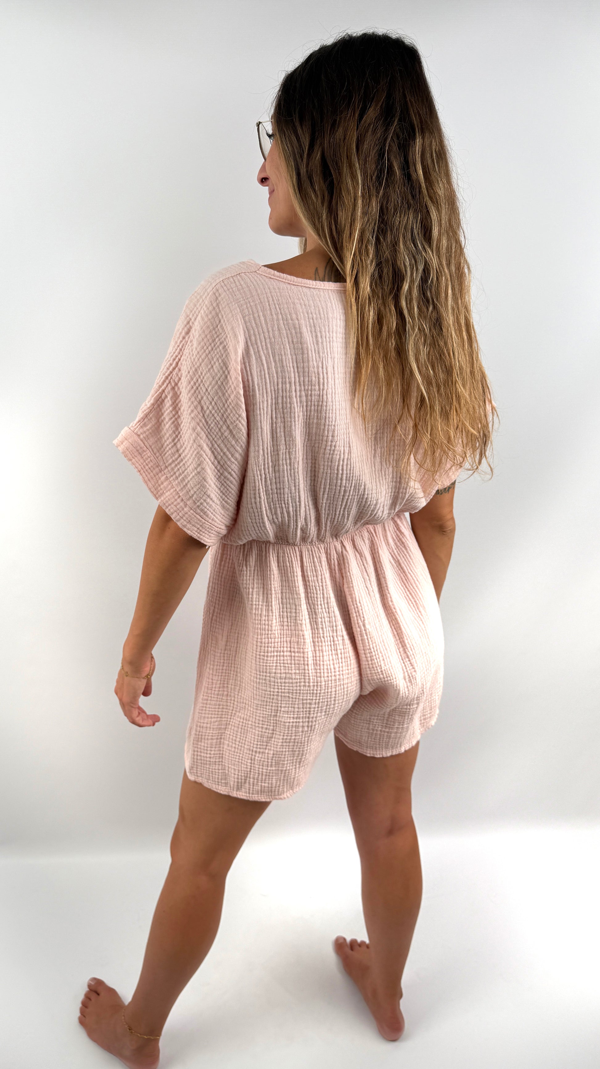 Rosa farbener Musselin Jumpsuit mit V-Ausschnitt und kurzen Armen und Beinen.