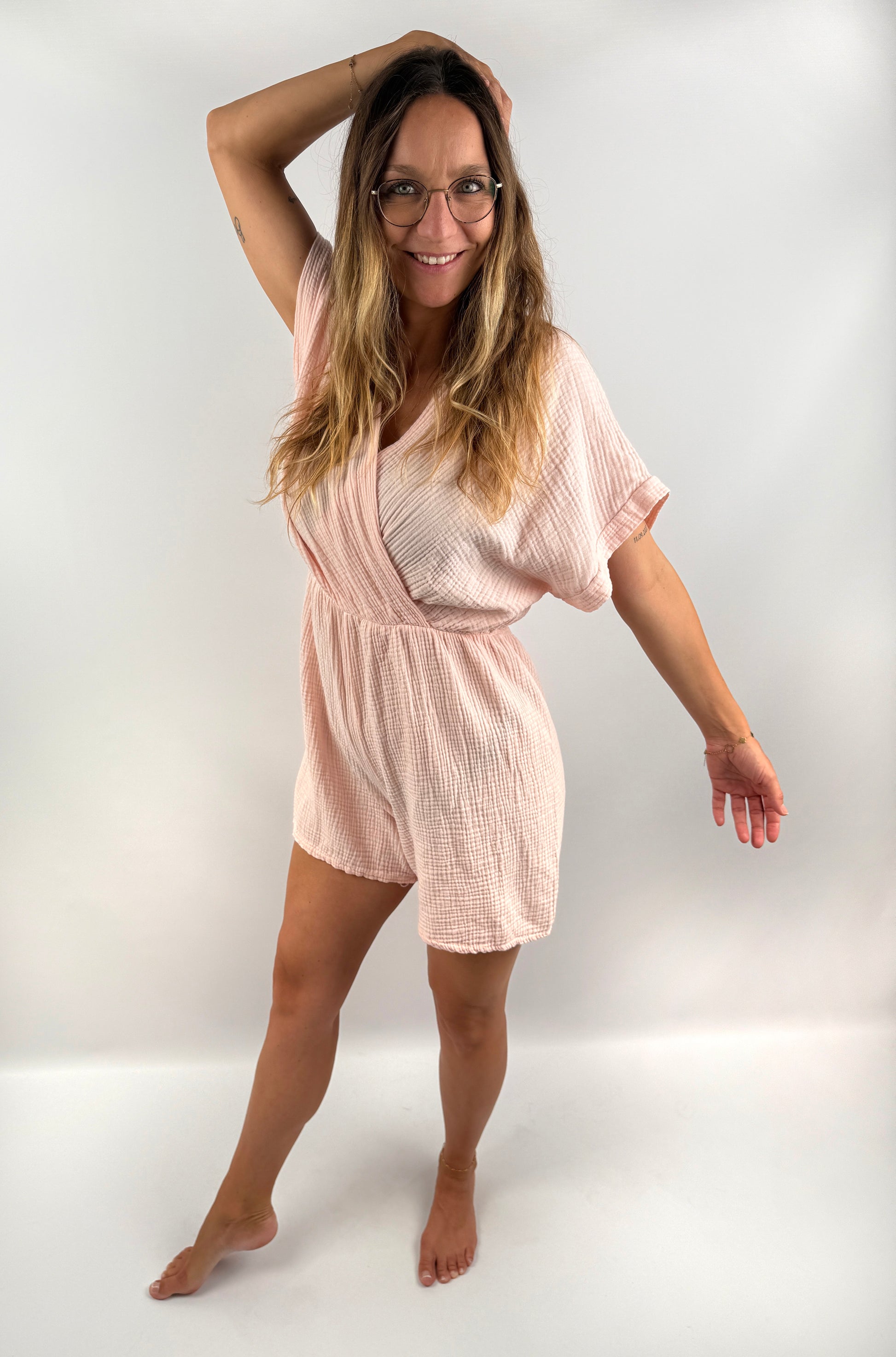 Rosa farbener Musselin Jumpsuit mit V-Ausschnitt und kurzen Armen und Beinen.