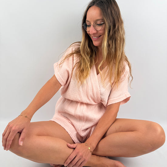 Rosa farbener Musselin Jumpsuit mit V-Ausschnitt und kurzen Armen und Beinen.