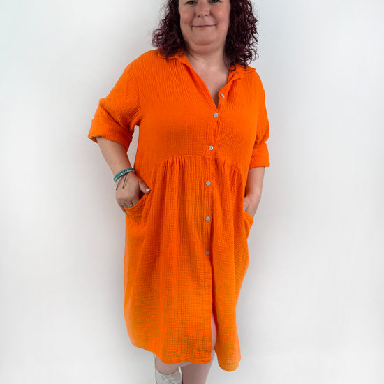XL Musselin Kleid mit Knopfreiehe und seitlichen Taschen und 3/4 Ärmeln in der Farbe Orange.