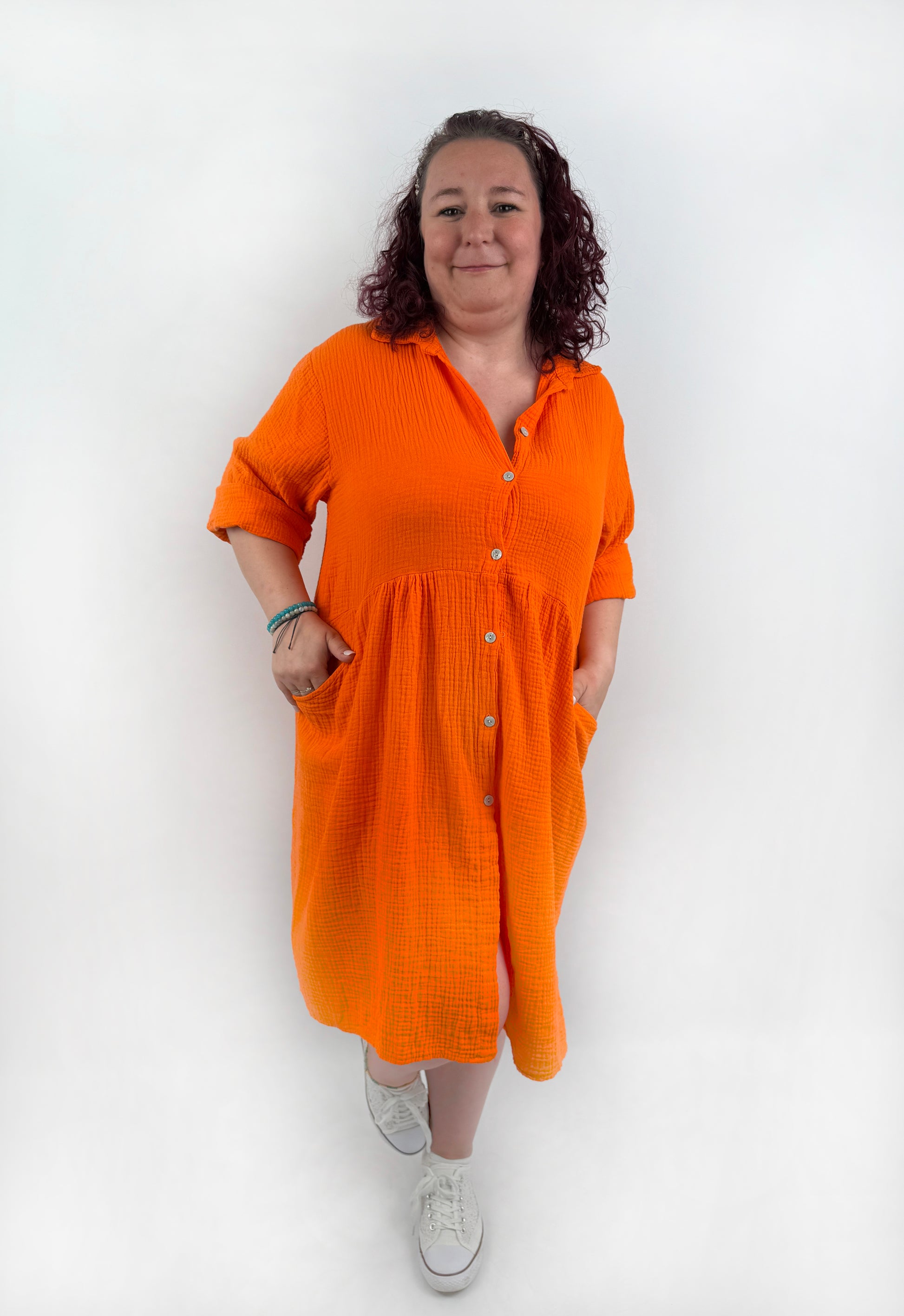 XL Musselin Kleid mit Knopfreiehe und seitlichen Taschen und 3/4 Ärmeln in der Farbe Orange.