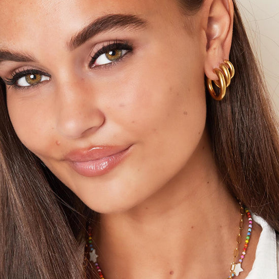 Massive mittelgroße Edelstahl Creolen in Gold.