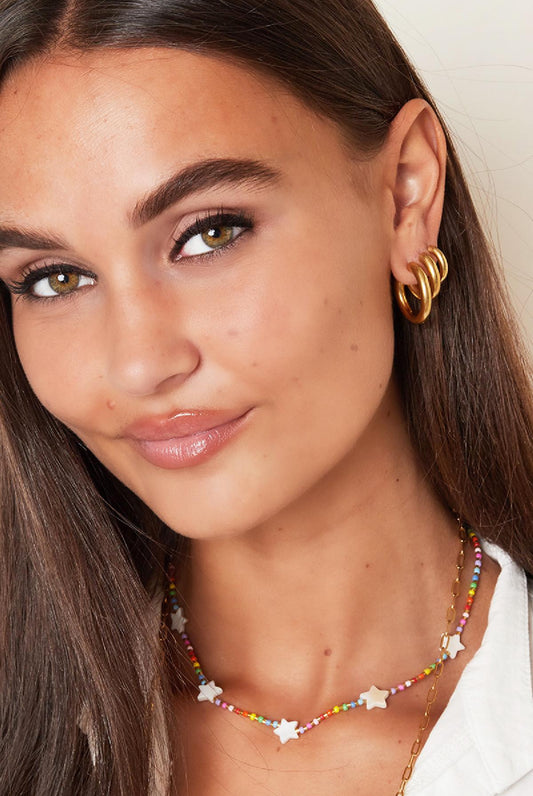 Massive mittelgroße Edelstahl Creolen in Gold.